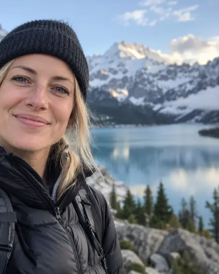 A traveller beside a mountain lake in winter